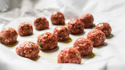 Raw uncooked meatballs on a baking sheet