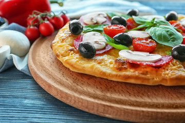 Delicious pizza and napkin on blue wooden background
