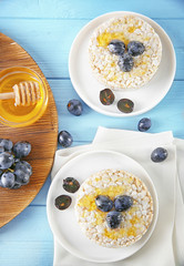 Tasty rice wafers with grape and honey on blue wooden table