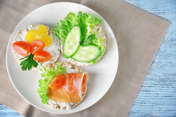 Tasty breakfast of rice wafers with vegetables and bacon on plate