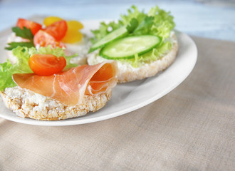 Tasty breakfast of rice wafers with vegetables and bacon on plate