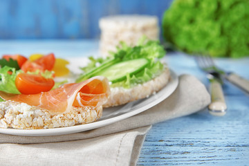 Tasty breakfast of rice wafers with vegetables and bacon on plate