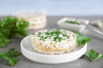 Rice wafers with cheese and parsley on grey table