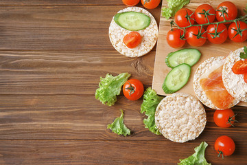 Fresh vegetables and rice wafers on wooden table