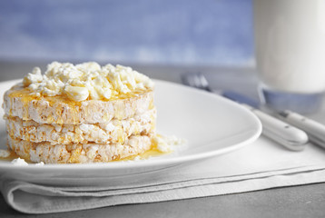 Healthy breakfast of rice wafers with curd cheese and glass of milk on a table