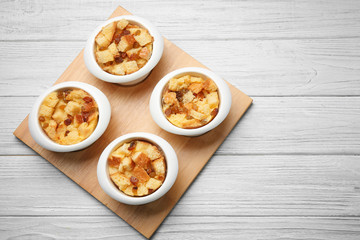 Baking bowls with bread pudding on wooden board