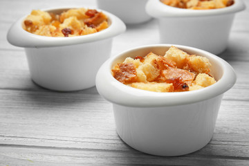 Baking bowls with bread pudding on wooden table