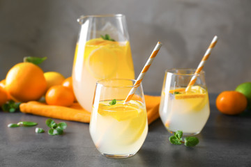 Glassware with refreshing citrus fruits cocktail on grunge background