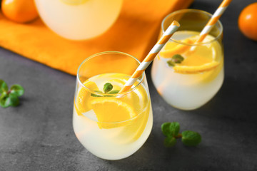 Glasses with refreshing citrus fruits cocktail on grunge background