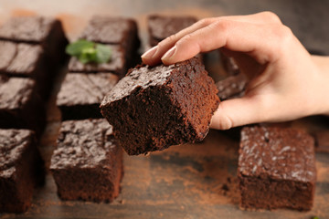Woman holding piece of delicious chocolate cake, closeup