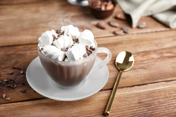 Cup of cocoa with marshmallows on wooden table