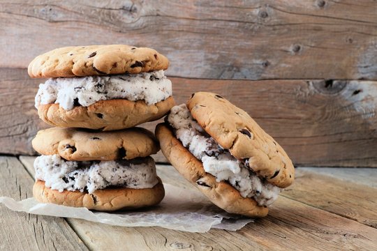 Homemade chocolate chip cookie ice cream sandwiches against a rustic wood background