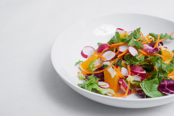 salad with radishes, carrots with greens;