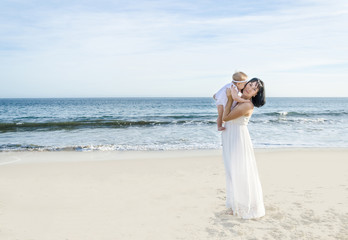 Fototapeta na wymiar Mother and her baby girl on the sandy beach