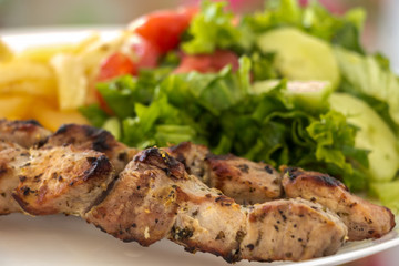 Souvlaki with salad and fried potatos.