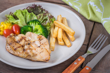 Grilled chicken steak and french fries on plate