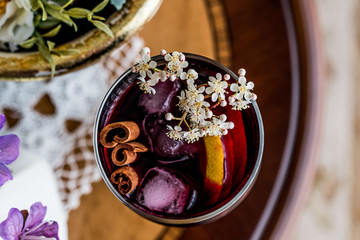 Sangria Cocktail in wine glass with lemon, cinnamon, fruits and ice.