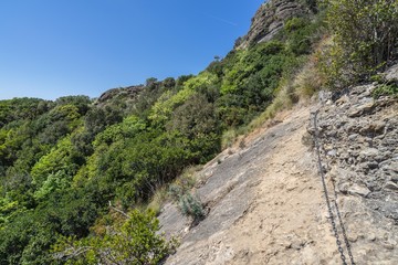 Walking on the rocks on Tigullio hiking trail, Liguria, Italy