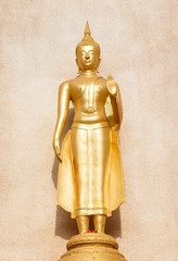 Golden standing buddha statue.