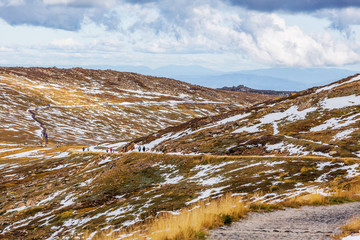 People walking on Mount Kosciuszko summit walk. Snowy Mountains, Australia