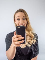Fototapeta premium blond woman on a white background, with cellphone