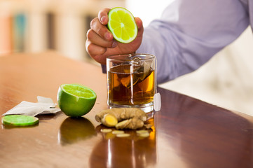 Man preparing a deleighful cup of tea with ginger and lemon home antimicrobial therapy