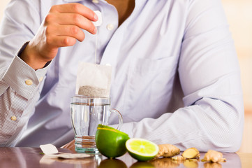 Man preparing a deleighful cup of tea with ginger and lemon home antimicrobial therapy