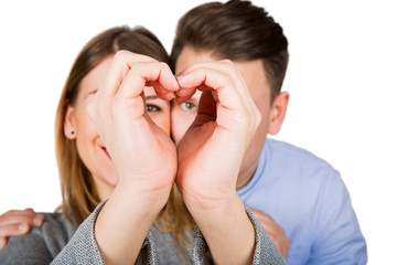 Young couple showing a heart sign
