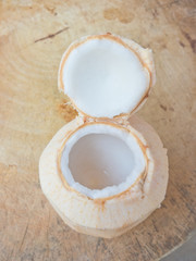 Coconut white flesh in an openning coconut shell on wood table
