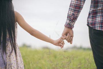 Father and daughter holding hand in hand at rice field. 