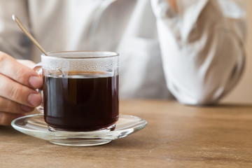 Man resting and drinking black coffee at the table in the cafe and thinking about work at lunch time. Coffee break.