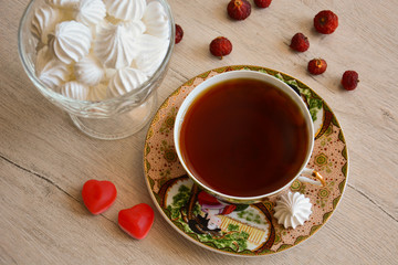 A cup of tea and a vase with meringue