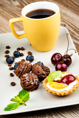 Cup of coffee and pastry on wooden background