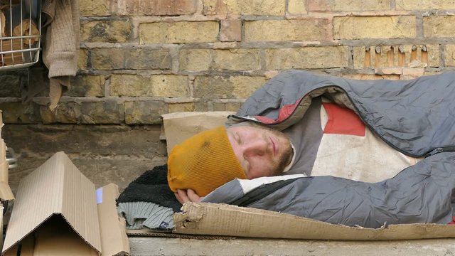 
4K. Homeless  man with carriage sleep near wall . Dolly shoot  close up
