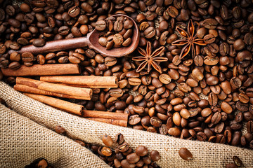 Coffee beans, ground coffee and cinnamon on burlap.