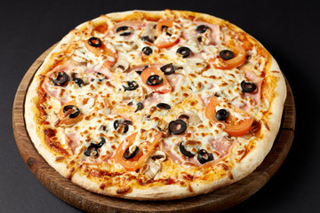 Hot pizza Regina on a rustic wooden table.