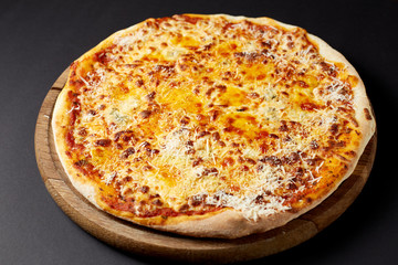 Hot pizza Quattro Formaggi on a rustic wooden table.