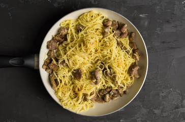 Pasta carbonara in the pan on rustic background. Shallow depth of field.