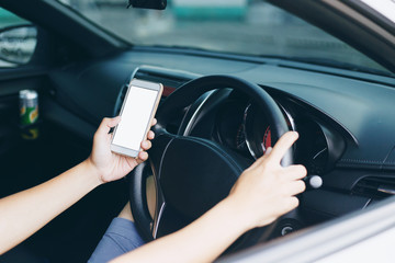 Naklejka premium Hand of driver using smartphone between driving because addict social media.