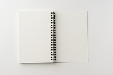 Business concept - Top view of spiral blank notebook on white background desk for mockup