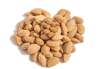 Almonds heart on isolated on white background, almonds in shells in the shape of a heart with some purified nuts on the top, happy valentines day, simplicity