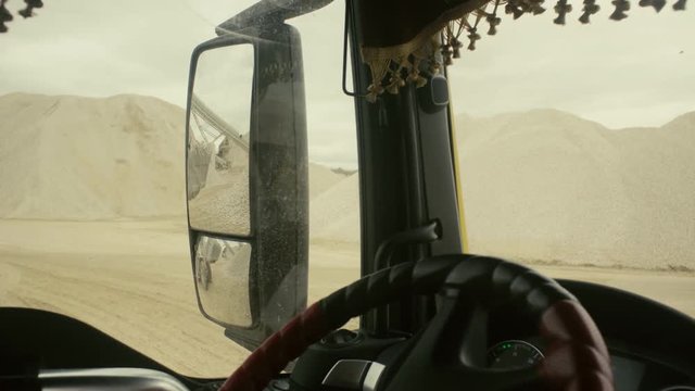 View in truck's rearview mirror on work in quarry