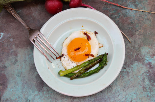 Fried eggs with bacon and asparagus. Rustic breakfast