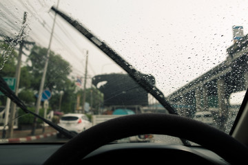Windshield wipers from inside of car, season rain.