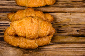 Fresh croissants on wooden table. Top view