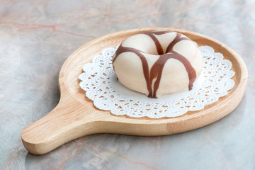 Glazed donut on wooden tray