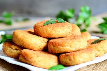 Small chickpea burgers on a plate. Fried vegan burgers made with chickpeas puree. Simple, healthy and hearty meal idea. Rustic stile. Closeup