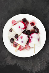 Ice cream from yogurt / coconut milk with blackberry and raspberry on a dark background. Top view. Food background