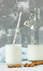 Almond milk in bottles on a gray background. Love for a healthy vegan food concept
