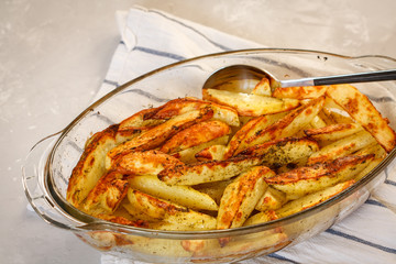 Homemade baked potatoes with spices in a glass form.